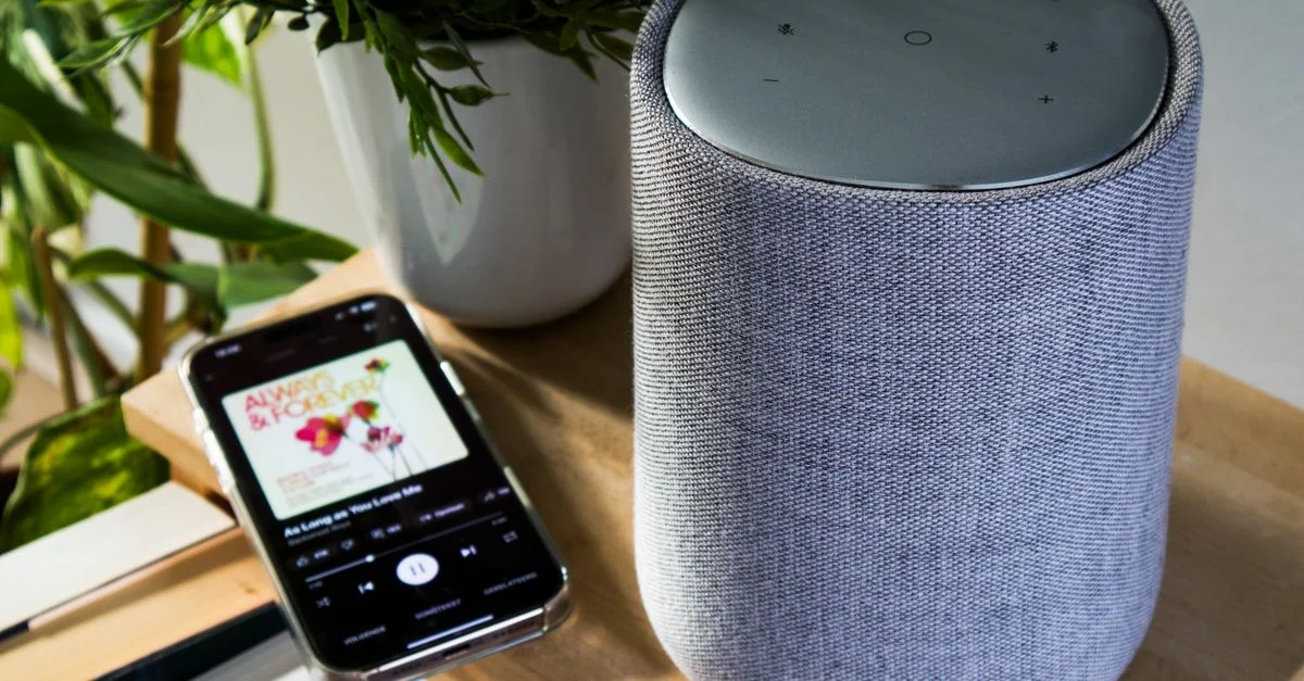 Enceinte Bluetooth et smartphone jouant de la musique sur une table à l'intérieur.