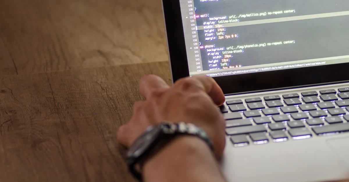 Une main de développeur interagissant avec du code sur l'écran d'un ordinateur portable dans un environnement de travail.