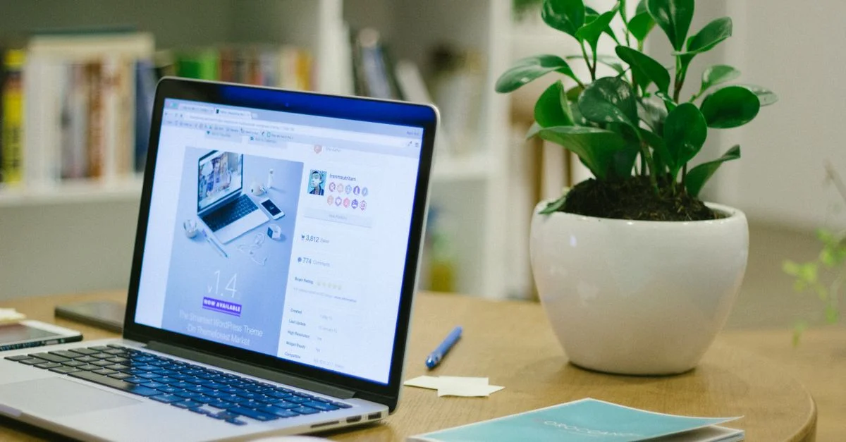 Un espace de travail moderne avec un ordinateur portable et une plante en pot sur un bureau, offrant un cadre frais et organisé.