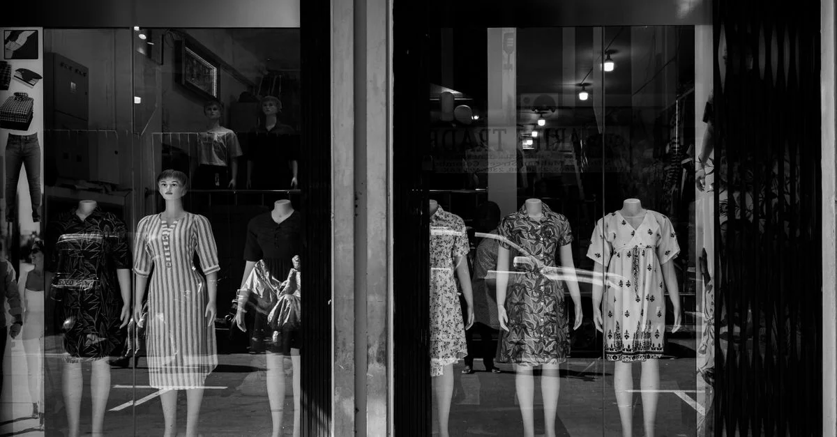 Une vitrine à Colombo, au Sri Lanka, présentant des mannequins vêtus de différentes robes, visibles à travers une vitre.